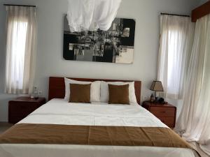 a bedroom with a large bed and two windows at Bendul Retreat in Tabanan