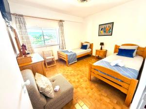 a bedroom with two beds and a couch in it at Marachique Beach Flat in Alvor