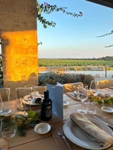 a table with wine glasses and a view of the vineyards at Glamping Masseria Cuturi in Manduria