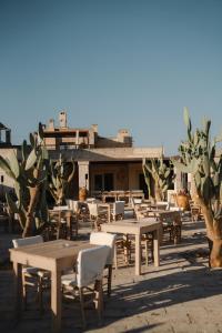 a group of tables and chairs in front of a building at Glamping Masseria Cuturi in Manduria
