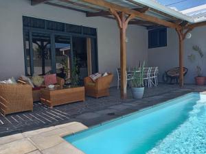 a patio with wicker furniture and a swimming pool at L'instant Varangue in Albion