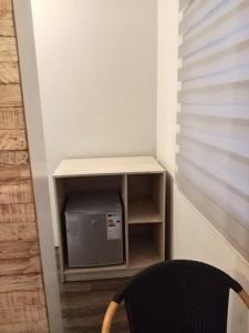 a small tv in a corner with a black chair at L'instant Varangue in Albion +12 photos
