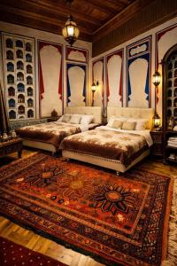two beds in a bedroom with a rug on the floor at Hotel Chorminor 110 m to Old Town GET EARLY CHECK IN AND CHECK OUT in Bukhara