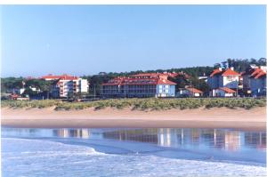 a view of a beach with houses and the water at Hotel las Dunas in Noja