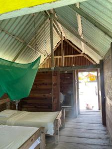 a room with two beds in a wooden house at Cabañas Wailidub, San Blas in Ogobsitupo