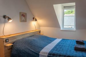 a bedroom with a blue bed and a window at Le petit baigneur, 300m de la mer et centre ville in Étretat