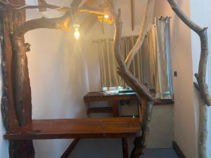 a room with a wooden bench and a tree branch istg at Osinoni Cottages in Isiolo +1 photo