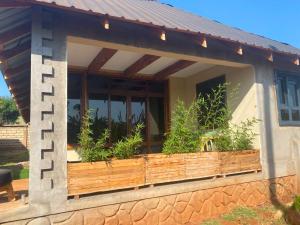 a house with a wooden balcony with plants in it at Osinoni Cottages in Isiolo