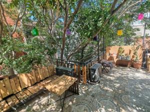a garden with a wooden bench and a tree at Shantihome in İzmir