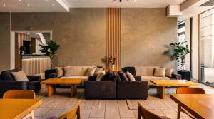 a living room with couches and tables at Athens Odeon Hotel in Athens