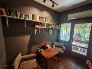 a room with a desk and chairs and a table with a lamp at Shantihome in İzmir