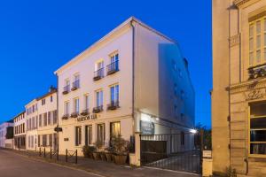 ein weißes Gebäude in einer Straße neben zwei Gebäuden in der Unterkunft Hotel Maison Lia in Châlons-en-Champagne