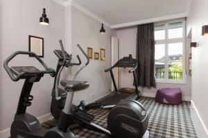 ein Fitnessstudio mit zwei Laufbändern und zwei Ergometern in der Unterkunft Hotel Maison Lia in Châlons-en-Champagne