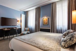 ein Hotelzimmer mit Bett und Fernseher in der Unterkunft Hotel Maison Lia in Châlons-en-Champagne