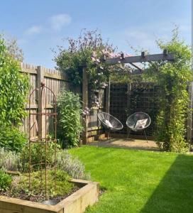 a garden with two chairs under a pergola at The nook in Rāmnagar +11 photos