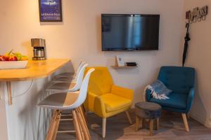 a room with chairs and a bar with a tv at Le grand bleu, 300m de la mer et centre ville in Étretat