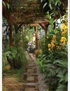 a garden with a wooden pergola and a stone path at The nook in Rāmnagar