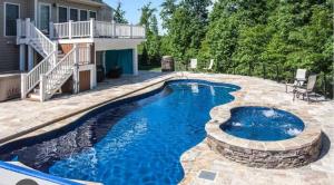 a swimming pool with a patio and a house at The nook in Rāmnagar