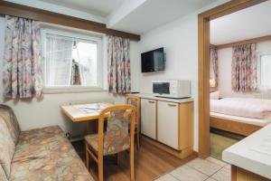 a small room with a bed and a desk and a table at Apart Waldblick in Serfaus