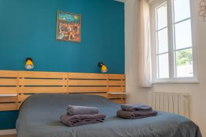 a blue bedroom with a bed with towels on it at Le grand bleu, 300m de la mer et centre ville in Étretat
