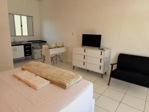 a bedroom with a bed and a desk and a chair at Golden Stay Suites in Jacareí