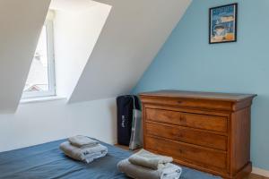 a bedroom with a bed with a dresser and two towels at Le grand bleu, 300m de la mer et centre ville in Étretat +9 photos