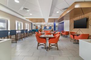 a waiting room with tables and chairs and a flat screen tv at Holiday Inn Express Biddeford by IHG in Biddeford