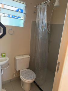 a bathroom with a toilet and a shower curtain at Golden Stay Suites in Jacareí