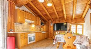 a large kitchen with a table and a television at Chalet le Vernès Marmotte in Bonneval-sur-Arc +8 photos