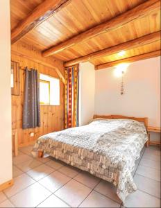 a bedroom with a bed in a room with wooden ceilings at Chalet le Vernès Marmotte in Bonneval-sur-Arc