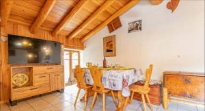 a dining room with a table and chairs and a television at Chalet le Vernès Marmotte in Bonneval-sur-Arc