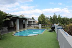 a backyard with a swimming pool and a house at Kanyane @ Graskop in Graskop