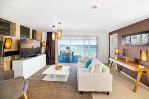 a living room with white furniture and a view of the ocean at Hôtel Baie des Anges in Gustavia
