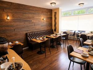 a restaurant with wooden walls and tables and chairs at Tregonholme Hotel in Bournemouth