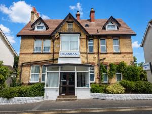 an old brick house with a sign that reads the hermitage inn at Tregonholme Hotel in Bournemouth