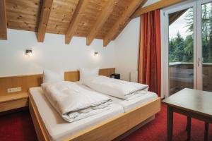 a bedroom with a bed and a table and a window at Apart Waldblick in Serfaus