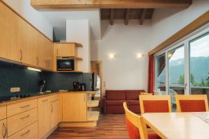 a kitchen with wooden cabinets and a table and a couch at Apart Waldblick in Serfaus