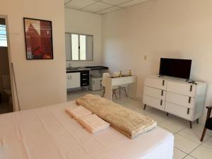 a bedroom with a bed and a desk and a television at Golden Stay Suites in Jacareí