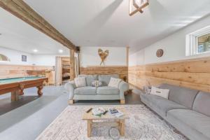a living room with a couch and a pool table at Pool Table et Nature - Chalet de la riviere in Saint-Alexis-des-Monts