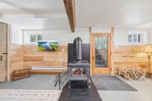 a living room with a stove and a tv at Pool Table et Nature - Chalet de la riviere in Saint-Alexis-des-Monts