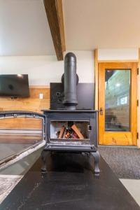 a stove in the middle of a room at Pool Table et Nature - Chalet de la riviere in Saint-Alexis-des-Monts +38 photos