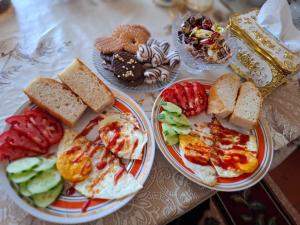 two plates of food with different types of bread and vegetables at OMKA Guest House in Toktogul +16 photos