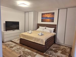 a bedroom with a bed and a flat screen tv at Vila Olive 51 in Tivat