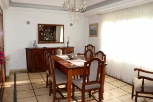 a dining room with a wooden table and chairs at Chalet 3 dormitorios MDP in Mar del Plata