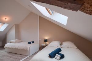 two beds in a room with a attic at Le Doumer - Centre-ville - Petfriendly in Château-Gontier