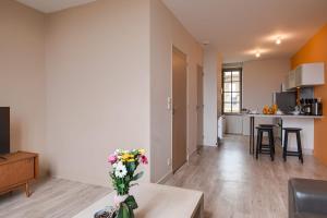 a living room with a vase of flowers on a table at Le Doumer - Centre-ville - Petfriendly in Château-Gontier