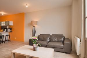 a living room with a couch and a table at Le Doumer - Centre-ville - Petfriendly in Château-Gontier