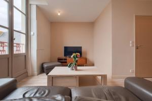 a living room with a couch and a table at Le Doumer - Centre-ville - Petfriendly in Château-Gontier +8 photos