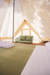 a tent with a green couch in the middle at Glamping Masseria Cuturi in Manduria