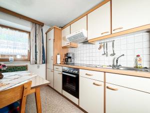 a kitchen with white cabinets and a sink at Haus Schönblick in Bschlabs +15 photos